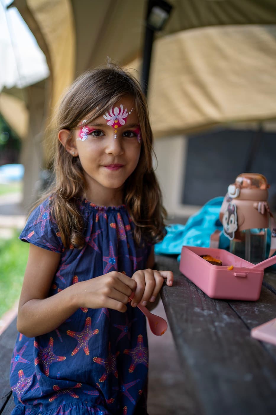 A child with butterfly face paint at lunch