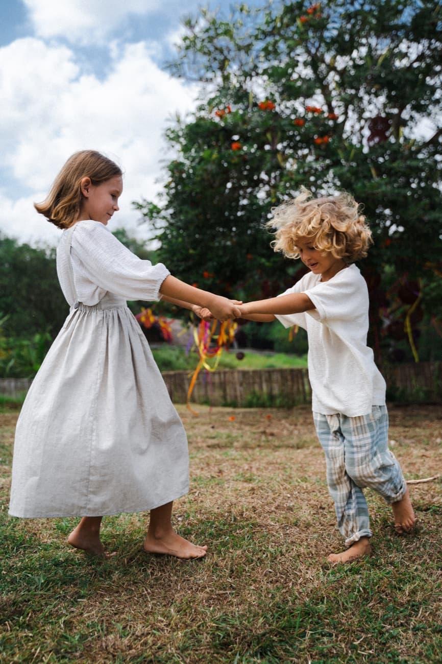 Two children holding hands and playing in the garden at Jungle Kids