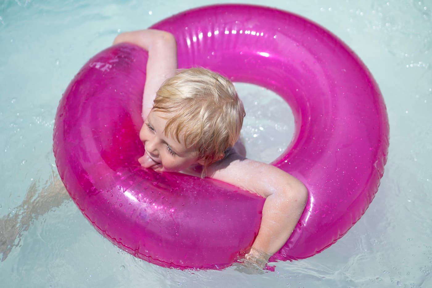 A happy child floating in the pool